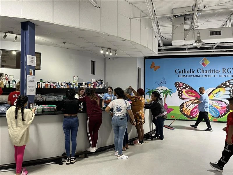 Volunteers and staff with Catholic Charities of the Rio Grande Valley assist Latin American and Haitian migrants at a migrant shelter in McAllen, Texas.?w=200&h=150